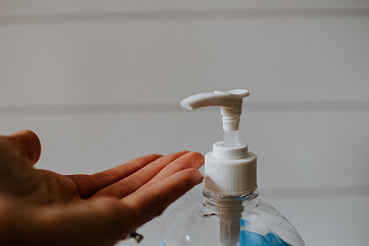 kelly-sikkema-f4ELzp_WuCk-unsplash Imagen de una mano junto a un bote de gel desinfectante